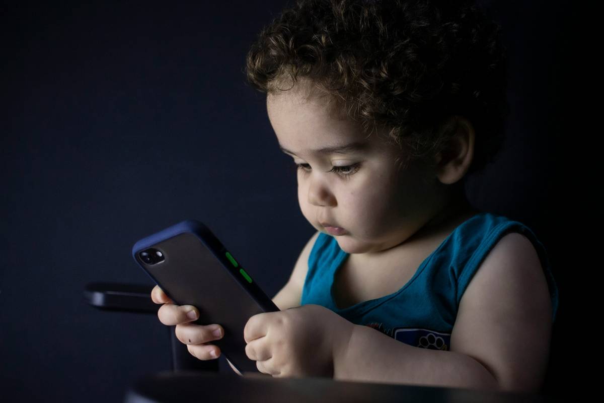 Kids' banking apps showing savings goal tracking on a tablet with parent and child
