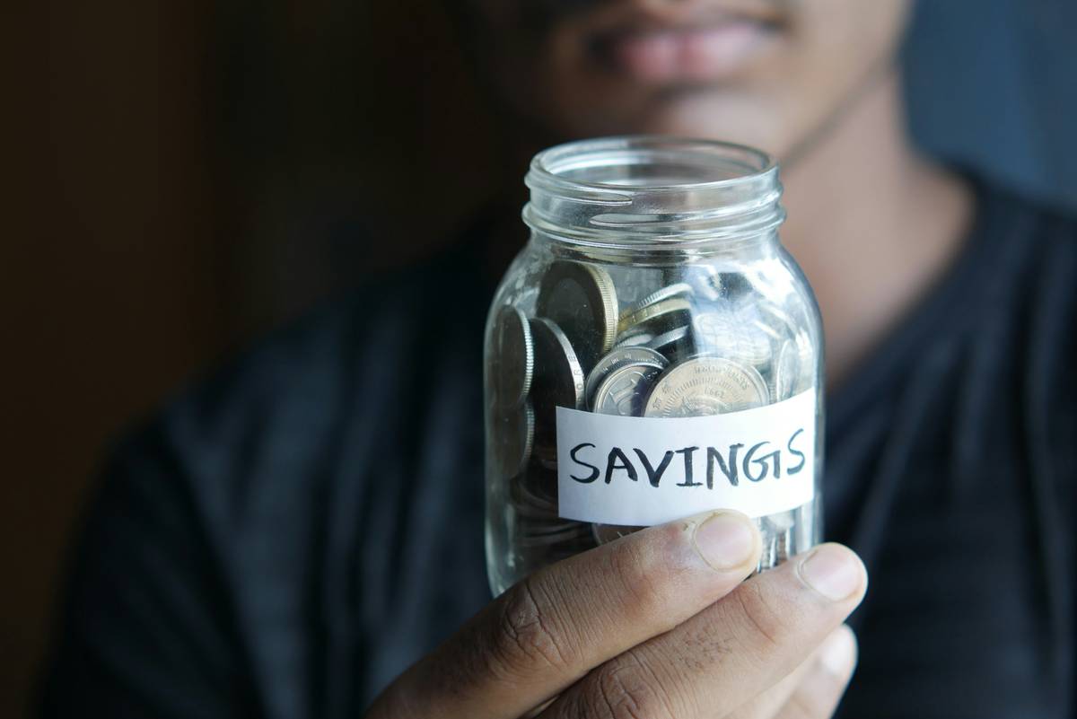 Youth financial challenges: A frustrated teenager reviewing bank statements with unexpected fees highlighted